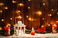 Christmas candle lantern and Christmas tree branches, snow, snowflake and decorations on bokeh background blurred lig Royalty Free Stock Photo