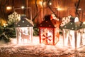 Christmas candle lantern and Christmas tree branches, snow, snowflake and decorations on bokeh background blurred lig Royalty Free Stock Photo