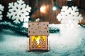 Christmas candle lantern and Christmas tree branches, snow, snowflake and decorations on bokeh background blurred lights Royalty Free Stock Photo