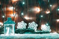 Christmas candle lantern and Christmas tree branches, snow, snowflake and decorations on bokeh background blurred lights Royalty Free Stock Photo