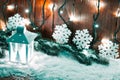 Christmas candle lantern and Christmas tree branches, snow, snowflake and decorations on bokeh background blurred lig Royalty Free Stock Photo