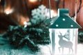 Christmas candle lantern and Christmas tree branches, snow, snowflake and decorations on bokeh background blurred lig Royalty Free Stock Photo