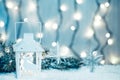 Christmas candle lantern and Christmas tree branches, snow, snowflake and decorations on bokeh background blurred lig