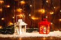 Christmas candle lantern and Christmas tree branches, snow, snowflake and decorations on bokeh background blurred lig Royalty Free Stock Photo