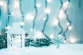 Christmas candle lantern and Christmas tree branches, snow, snowflake and decorations on bokeh background blurred lig