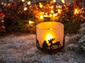 Christmas candle is standing in the snow.