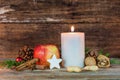 Christmas candle with star cookie, red apple, nuts and spices Royalty Free Stock Photo