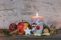 Christmas candle with star cookie, red apple, nuts and spices Royalty Free Stock Photo