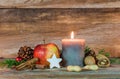 Christmas candle with star cookie, red apple, nuts and spices Royalty Free Stock Photo