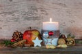 Christmas candle with star cookie, red apple, nuts and spices Royalty Free Stock Photo