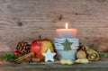 Christmas candle with star cookie, red apple, nuts and spices Royalty Free Stock Photo