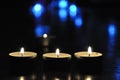 Christmas candles burning at night.  Golden light of three candle flame. Decoration,abstract candles background. Royalty Free Stock Photo