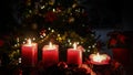 Christmas 4 candles flame red,flowers with illuminated tree to background