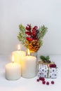 Christmas candles with a gift box and a pine branch on a white background. New Year card. Christmas collection Close up