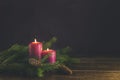 Christmas candles and lights. Two burning candles with fir branch and cones over wooden background, still life Royalty Free Stock Photo