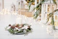 Christmas candles and snowy fir branches over white wooden background with lights.  New Year`s decoration with a fir tree in whit Royalty Free Stock Photo