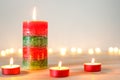 Christmas candles and tealights on wooden table with defocused holiday lights in background Royalty Free Stock Photo