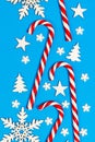 Christmas candy cane lied evenly in row on blue background with decorative snowflake and star. Flat lay and top view Royalty Free Stock Photo