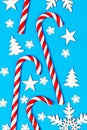 Christmas candy cane lied evenly in row on blue background with decorative snowflake and star. Flat lay and top view Royalty Free Stock Photo
