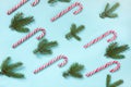 Christmas candy cane lied evenly in row on blue background. Flat lay and top view. Royalty Free Stock Photo
