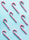 Christmas candy cane lied evenly in row on blue background. Flat lay and top view. Pattern. Royalty Free Stock Photo