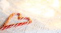 Christmas candy cane striped Santa in the form of heart on a white knitted blanket. A symbol of love, a gift to a loved one, a swe Royalty Free Stock Photo