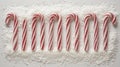 Christmas candy canes arranged in a row on a snowy surface Royalty Free Stock Photo
