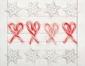 Christmas Candy Canes in Center and Wooden Snowflake Borders on White Wood Boards Background.  It`s horizontal with a flat layout Royalty Free Stock Photo