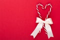 Christmas candy canes, stick and decor on color background. Christmas candy cane heart on an red background Royalty Free Stock Photo