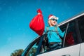 Christmas car travel- happy girl with presents enjoy winter vacation