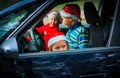 Christmas car travel- happy kids travel by car in winter Royalty Free Stock Photo