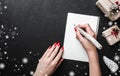 Christmas card background - Woman hands with red nails writing letter with wooden pencil. Royalty Free Stock Photo