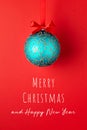 Christmas card with ball hanging on red ribbon. Royalty Free Stock Photo