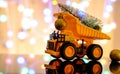 Christmas card. Children`s truck carries a Christmas tree. Bokeh, multicolor color. Light blurred background