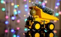 Christmas card. Children`s truck carries a Christmas tree. Bokeh, multicolor color