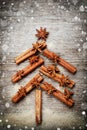 Christmas card with Christmas fir tree made from spices cinnamon sticks, anise star and cane sugar on rustic wooden background, ma Royalty Free Stock Photo