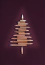 Christmas card with colorful pencils as christmas tree - burgundy cardboard background