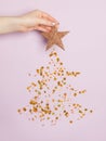 Christmas card composition with Xmas tree made from falling golden confetty stars on pastel purple background Royalty Free Stock Photo