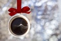 Christmas card- cup of fragrant hot coffee with smoke made from Christmas ball, bauble hangs on a red ribbon