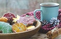 A cup of hot tea stands on a wooden table next to a wooden plate on which are gingerbread cookies made from orange Royalty Free Stock Photo
