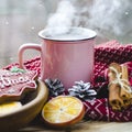 A cup of hot tea stands on a wooden table next to a wooden plate on which are gingerbread cookies made from orange slices against Royalty Free Stock Photo