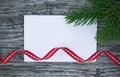 Christmas card: empty paper form with fir-tree branches on wooden background