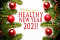 Festive background made of Christmas decorations with message `Wishing you a HEALTHY NEW YEAR 2021`