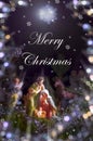 Christmas card with figures of Jesus, Virgin Mary and Joseph on a dark background with the inscription Merry Christmas