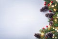 Christmas card. Fir tree branches with cones, red berries and light garland on white background. Top view with space for text Royalty Free Stock Photo