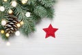 Christmas background. Fir tree on white wooden background with lights and red star Royalty Free Stock Photo