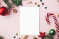 Christmas card flat lay. Modern greeting card mock up and red christmas decorations and ornaments on pink paper. Empty postcard Royalty Free Stock Photo