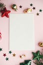 Christmas card flat lay. Modern greeting card mock up and red christmas decorations and ornaments on pink paper. Empty postcard Royalty Free Stock Photo