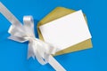 Christmas card with gift ribbon bow in white satin on blue paper background, copy space Royalty Free Stock Photo