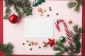 Christmas card mockup. Empty greeting card flat lay with red christmas decorations, fir branches and ornaments on pink background Royalty Free Stock Photo